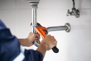 plumber at work in a bathroom, plumbing repair service